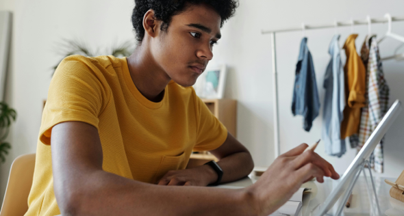 Teen boy working on his laptop.
